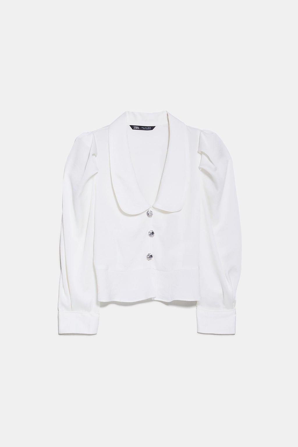 Blusa de Zara. Blusa blanca con botones joya