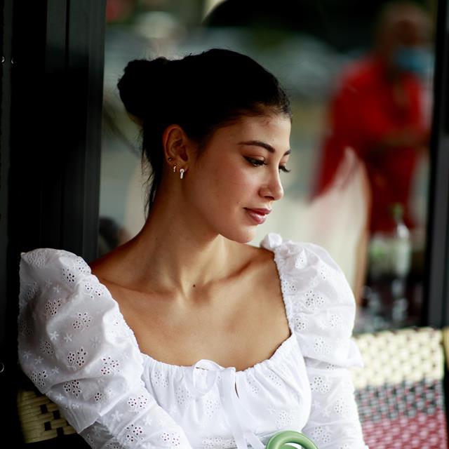 Chica con vestido blanco y bolso verde
