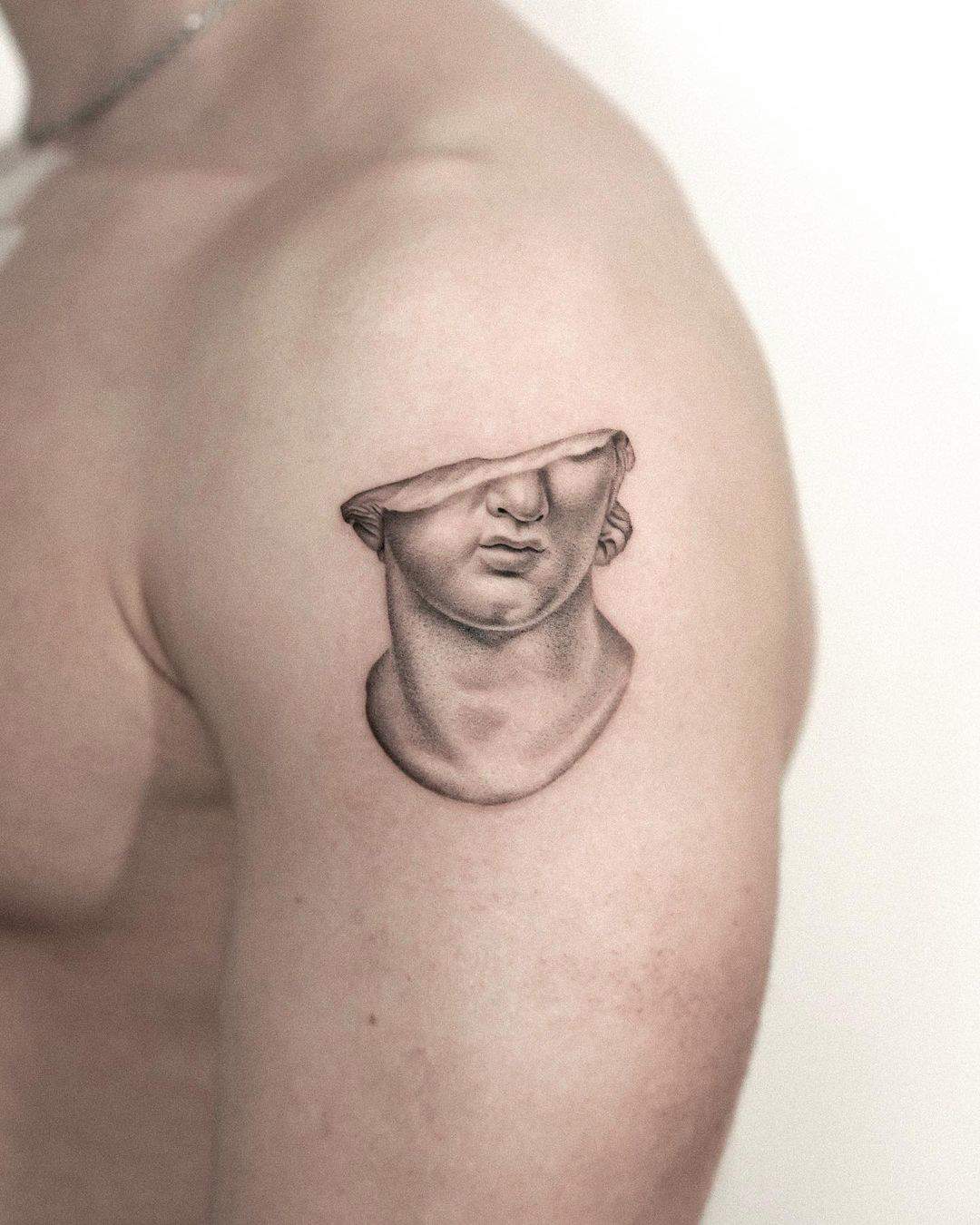 Una cabeza colosal fragmentada hecha tattoo