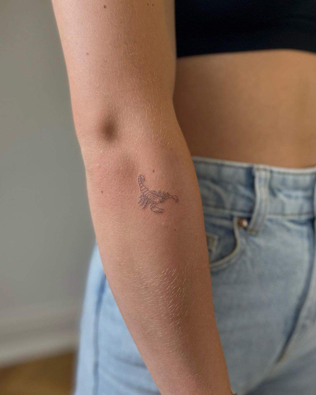 Un escorpión tatuado en el antebrazo