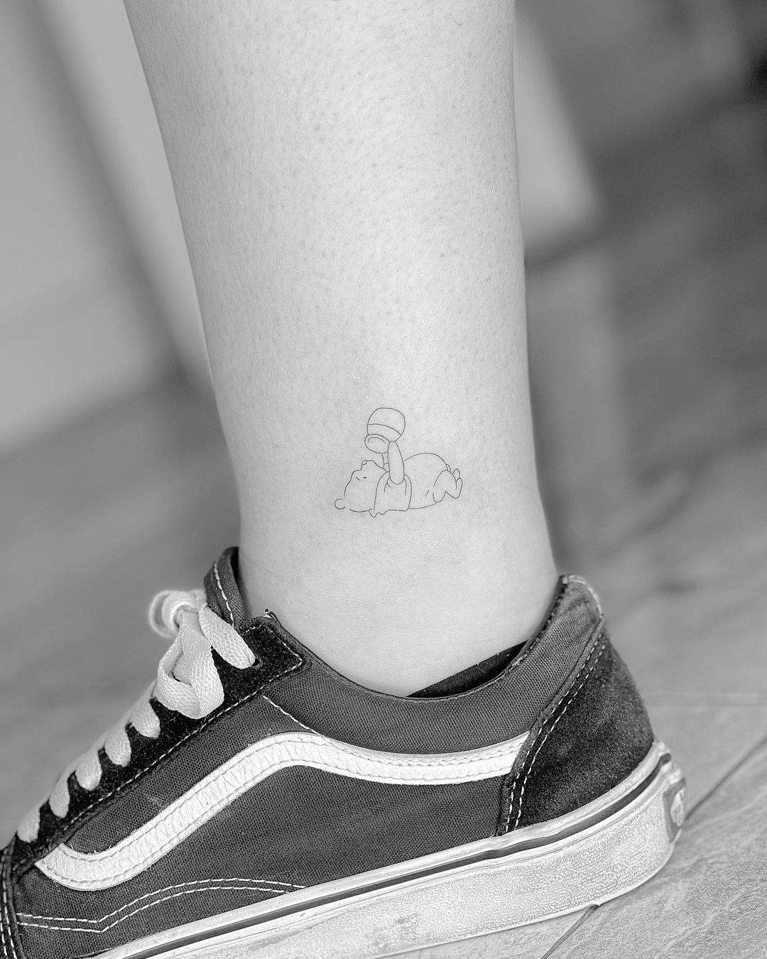 Tatuaje de Winnie the Pooh en trazo fino