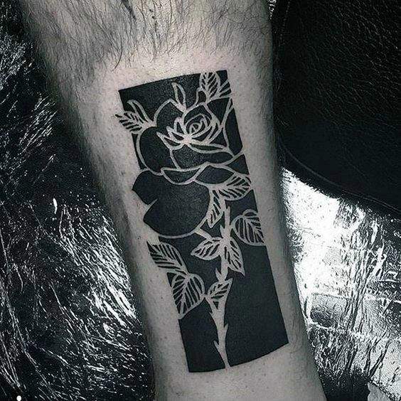 Tatuaje en el brazo para hombre de flor en negativo