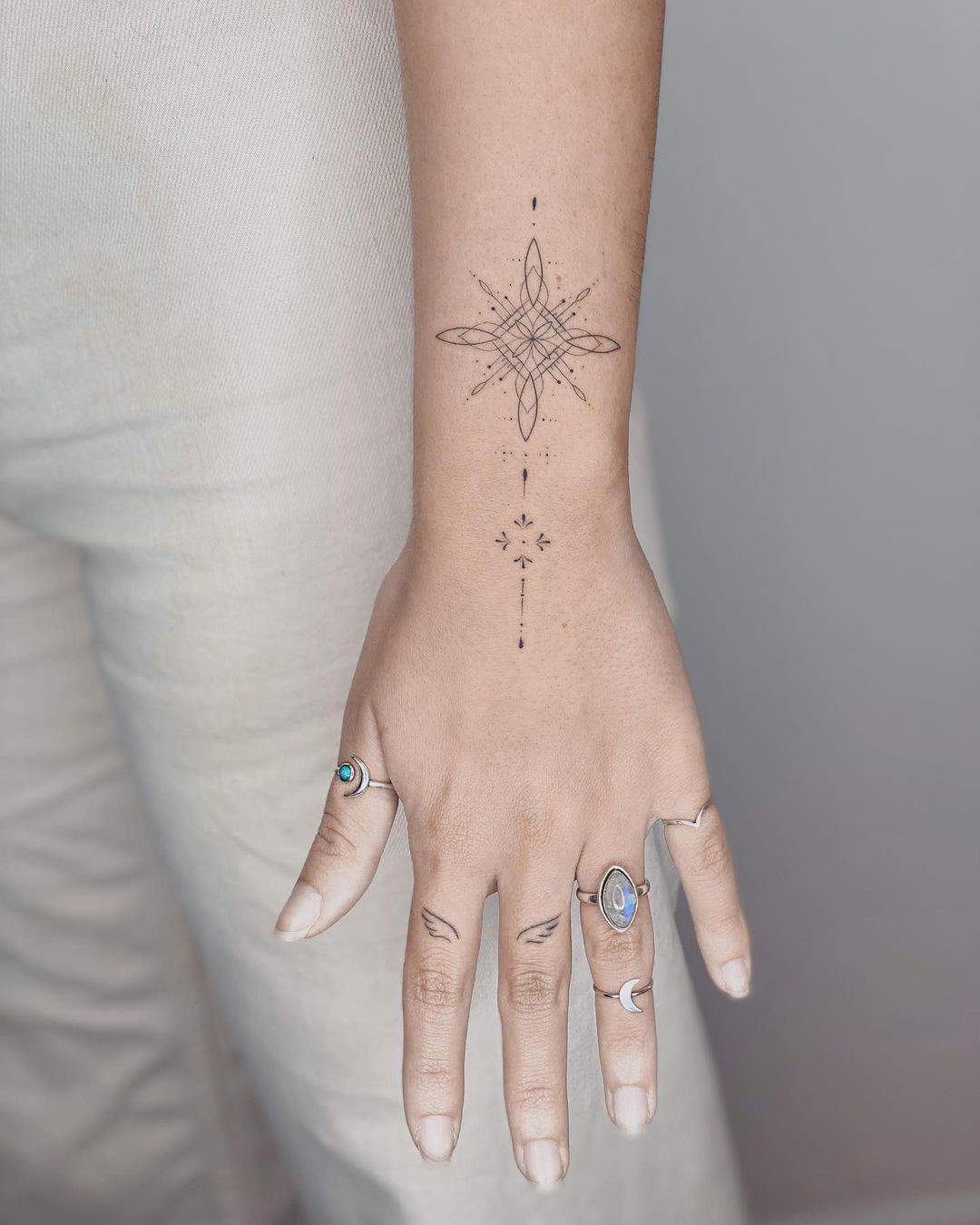 Varios motivos tatuados sobre la mano y los dedos