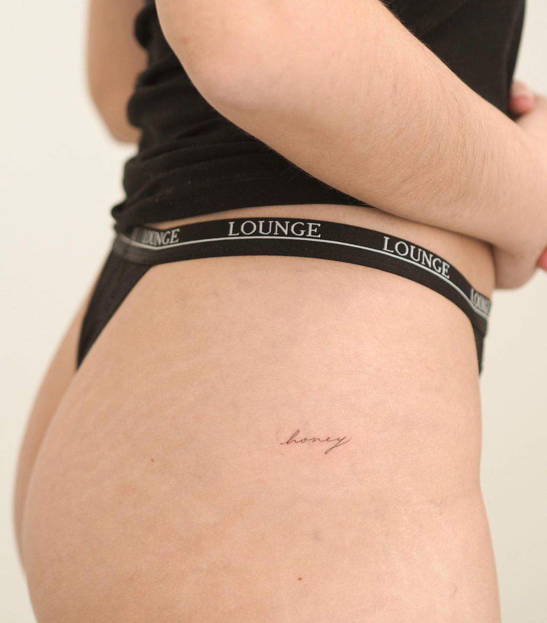 Tatuaje de palabra 'honey' en la cadera