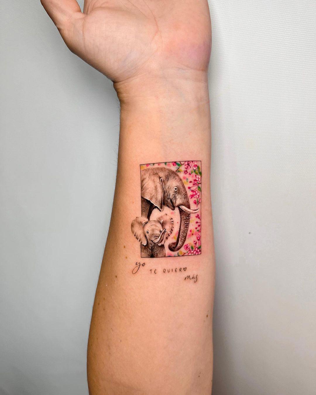 Tatuaje de elefantes con flores y frase