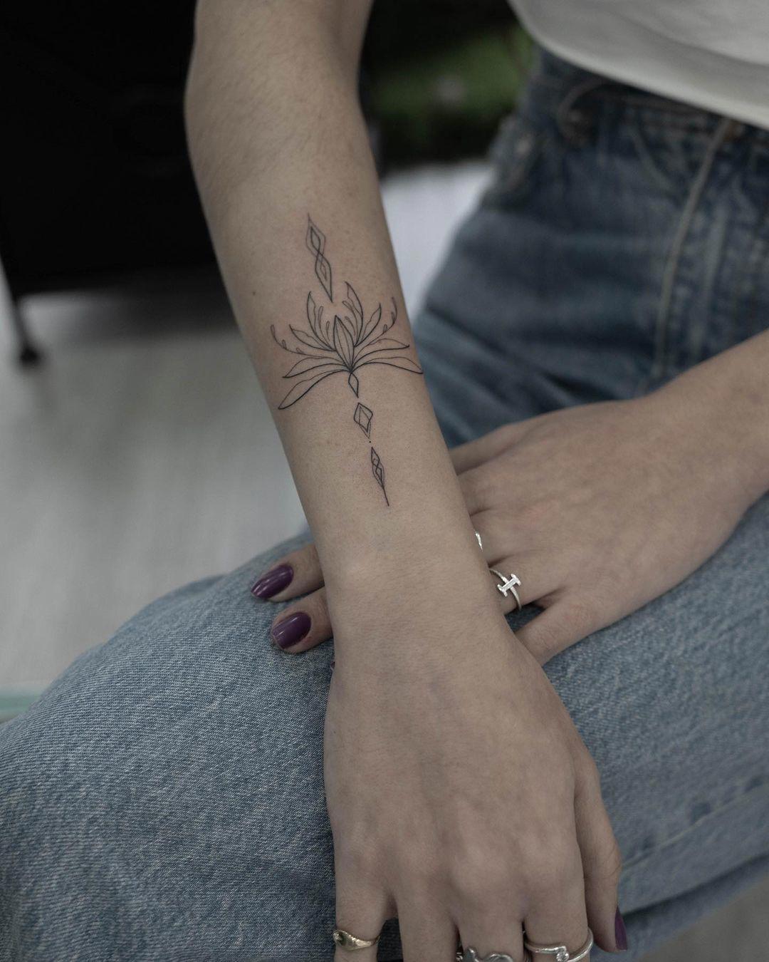 Una flor de loto tatuada en el antebrazo