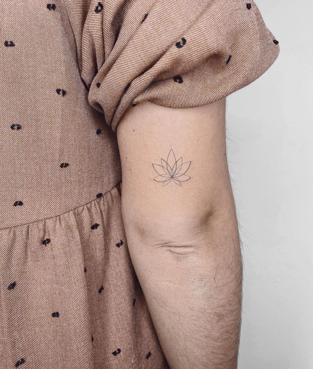 Tattoo en clave minimal de flor de loto sobre el codo