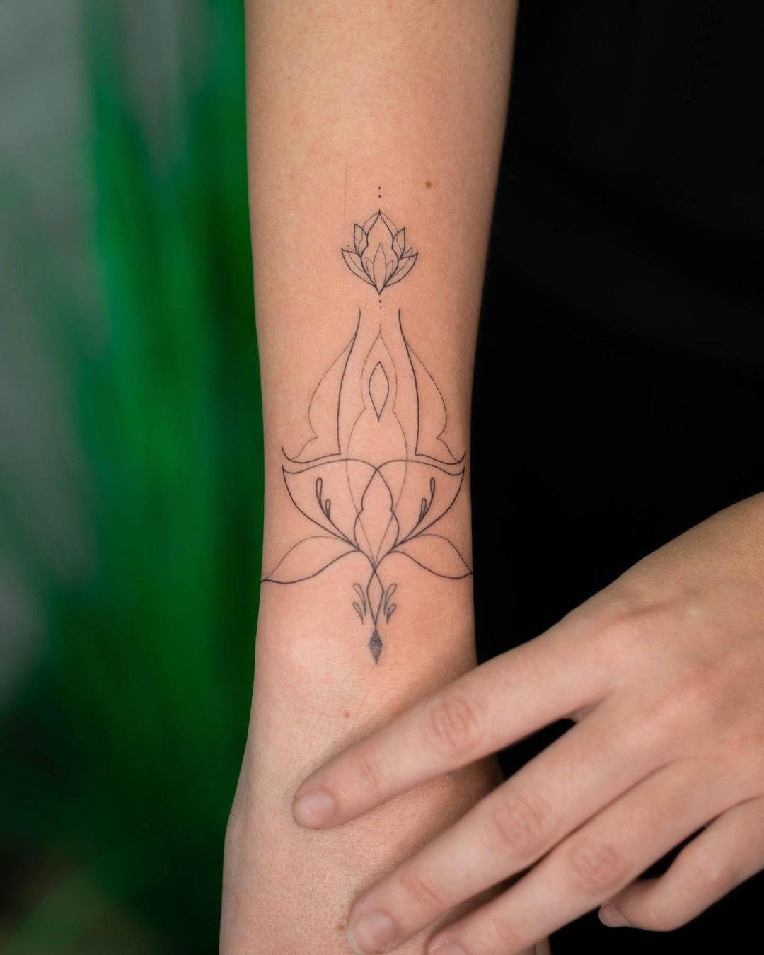 Tattoo en el antebrazo de mandala y flor de loto