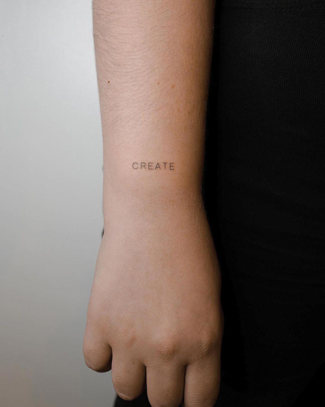 La palabra 'create' tatuada en mayúsculas
