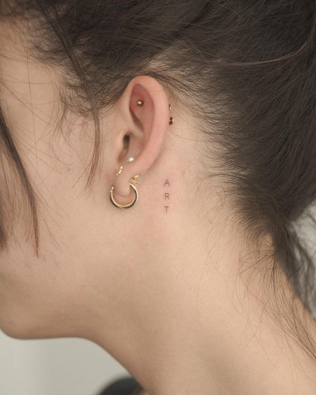 La palabra 'art' tatuada tras la oreja