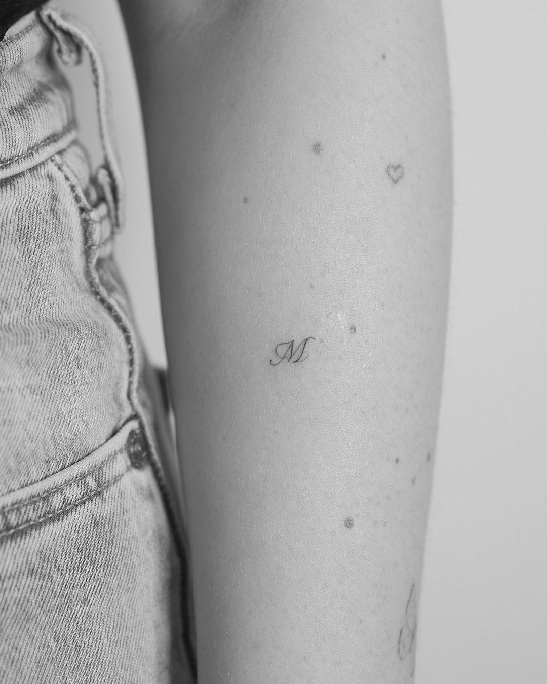 Tattoo de inicial en el antebrazo