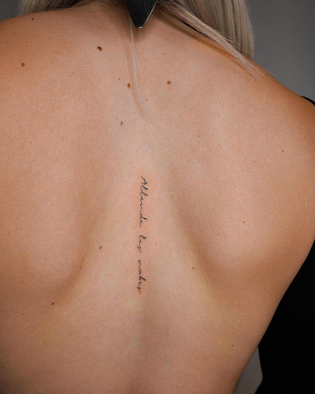 Tatuaje con letra script en la espalda
