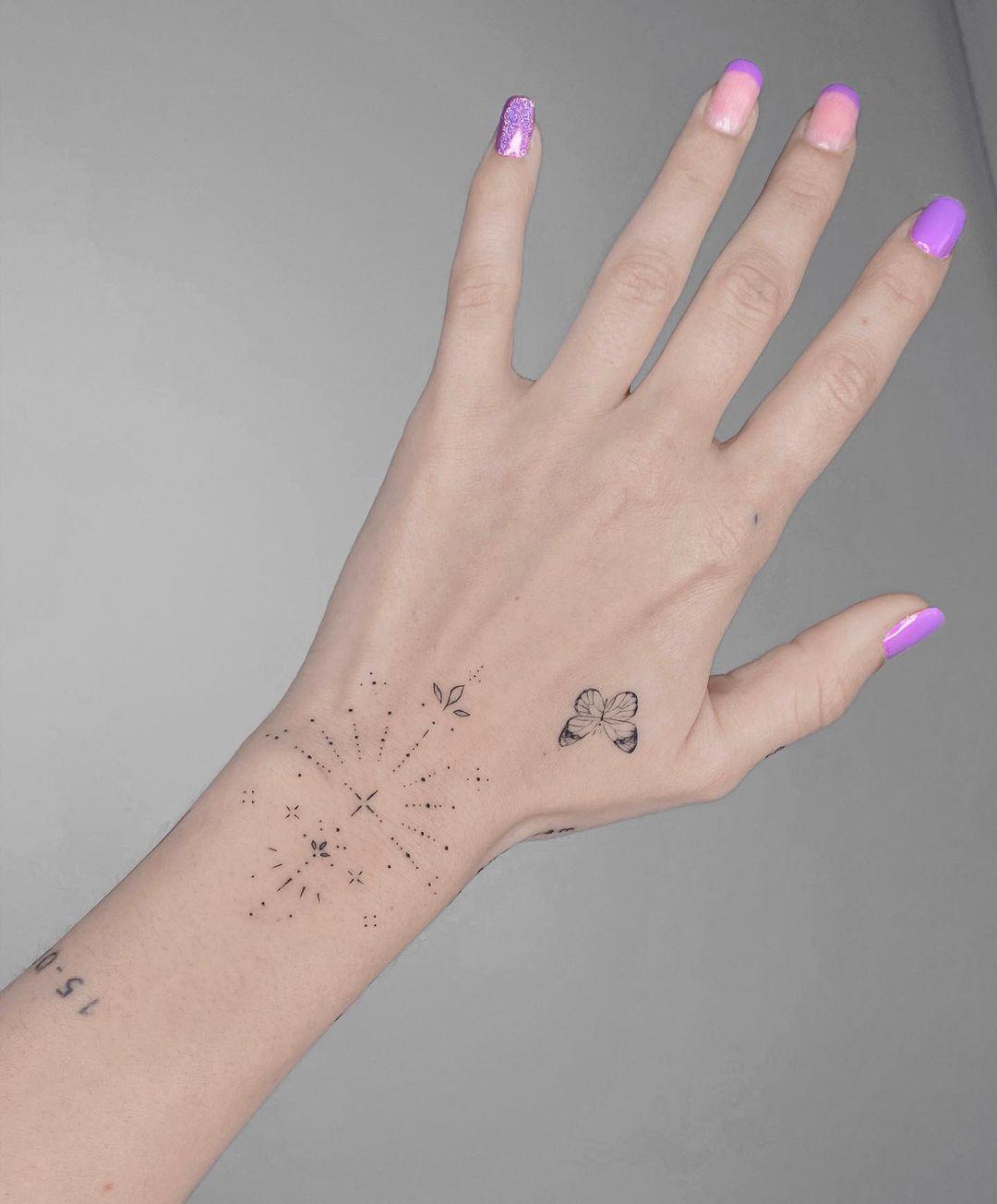 Tattoo de mariposa de trazo fino en la mano