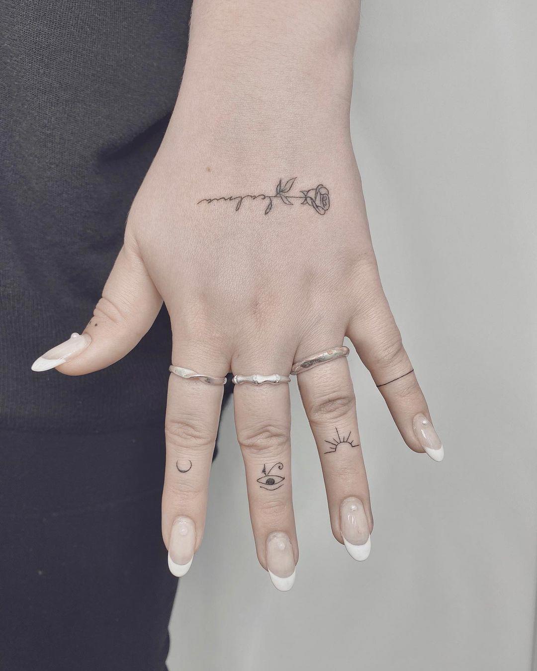 Tatuajes simbólicos en dedos y mano