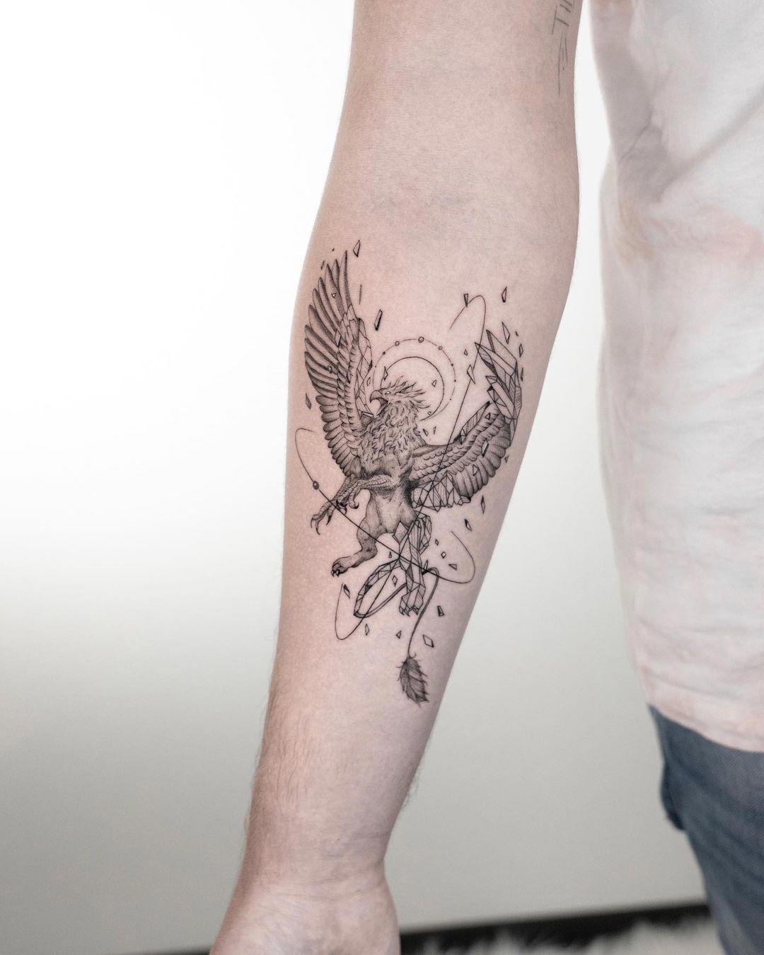 Tatuaje de ave fénix en el antebrazo
