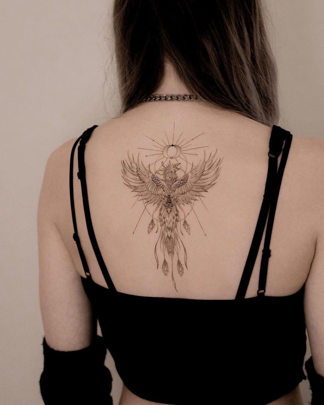 Tatuaje del ave fénix en el centro de la espalda