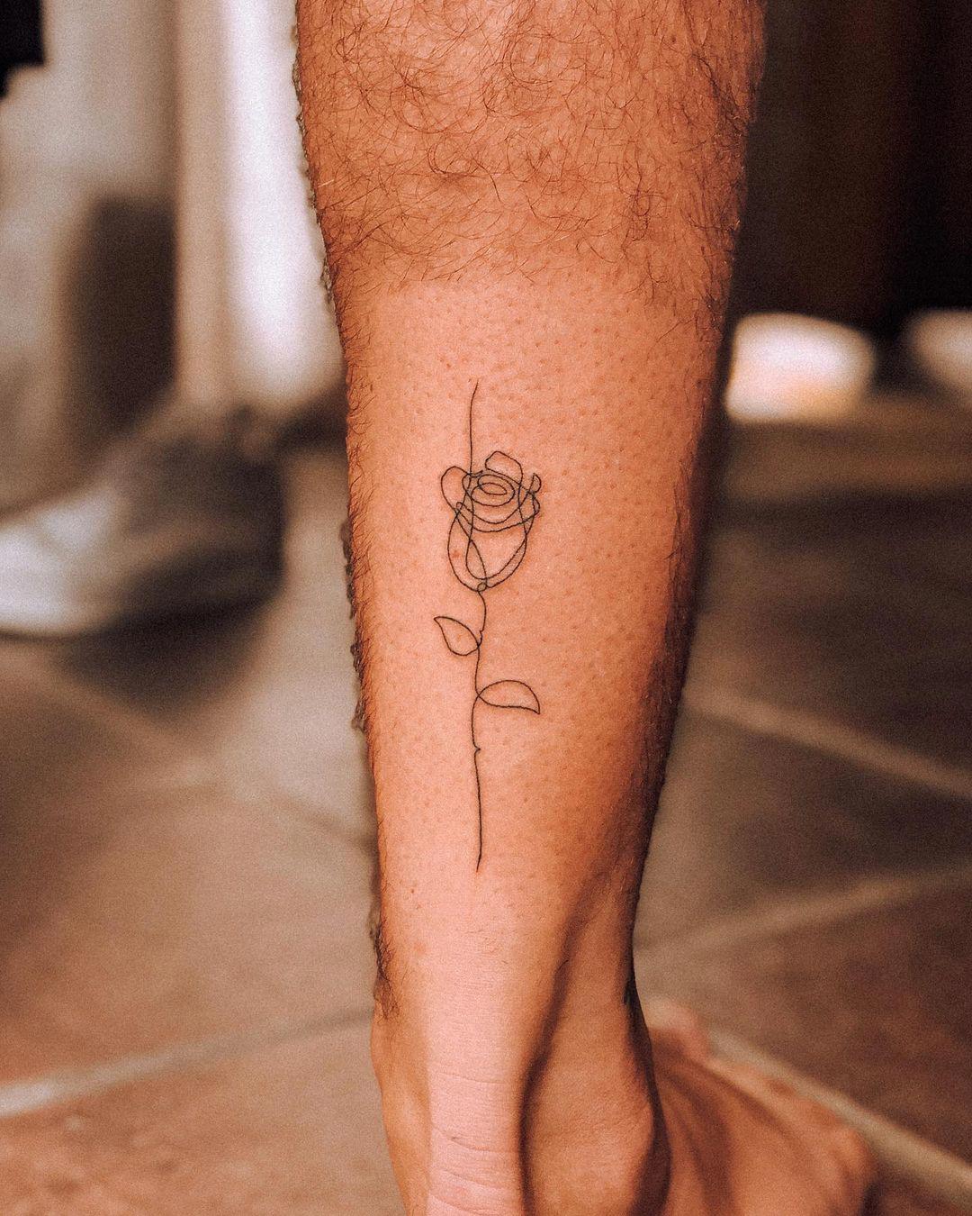 Tattoo de rosa minimalista en la pierna
