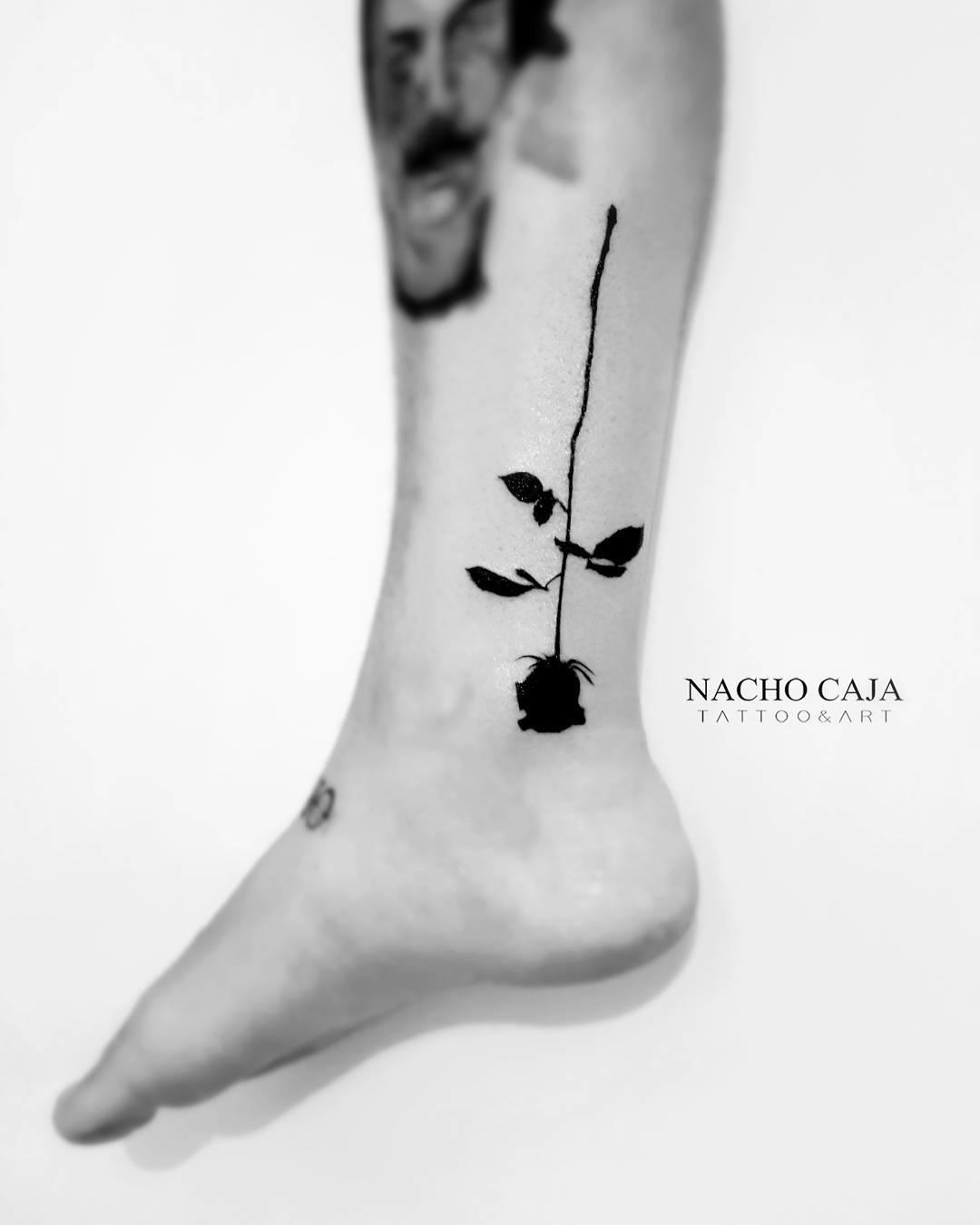 Tatuaje de una rosa negra en la pierna