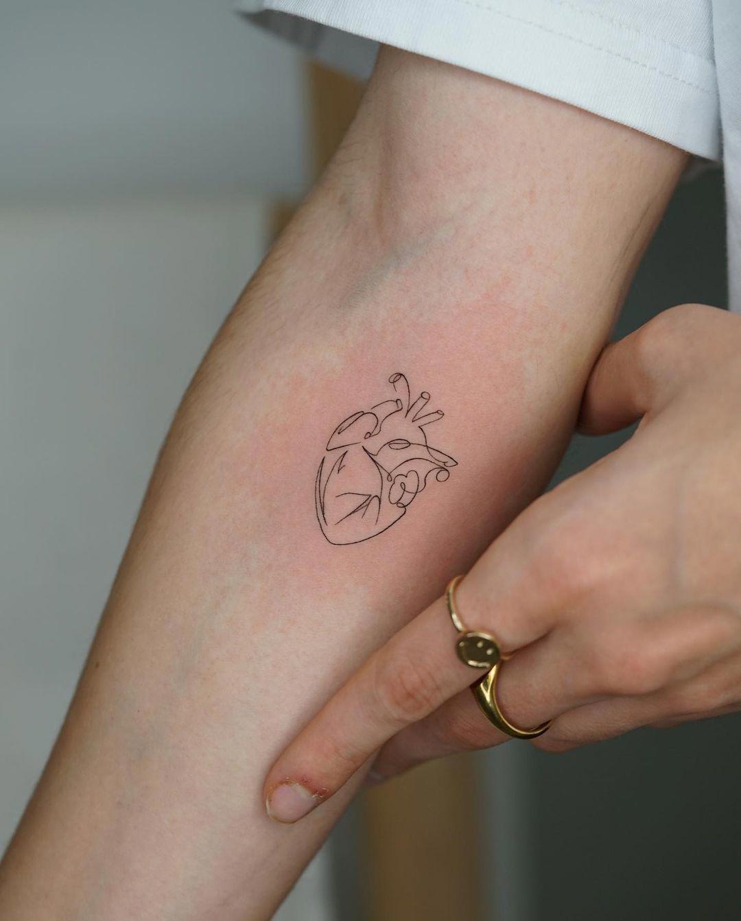 Tatuaje ‘fine line’ en el antebrazo de corazón 