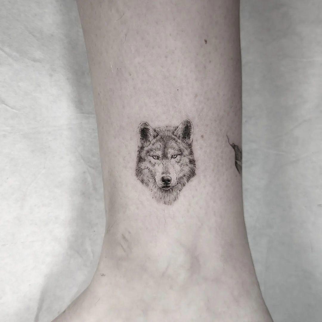 Tatuaje pequeño de lobo en el tobillo