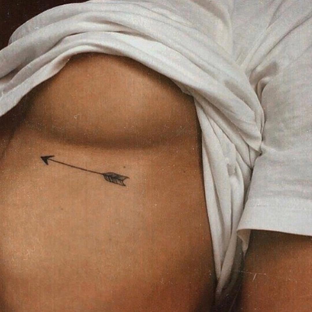 Tatuaje de flecha bajo el pecho