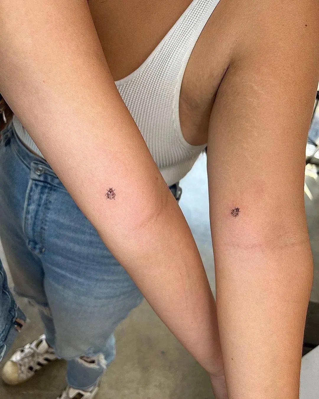 Mariquitas diminutas tatuadas en el brazo