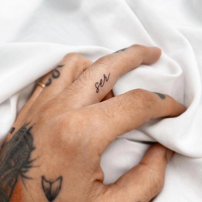 Tatuaje de la palabra 'ser' en el dedo anular