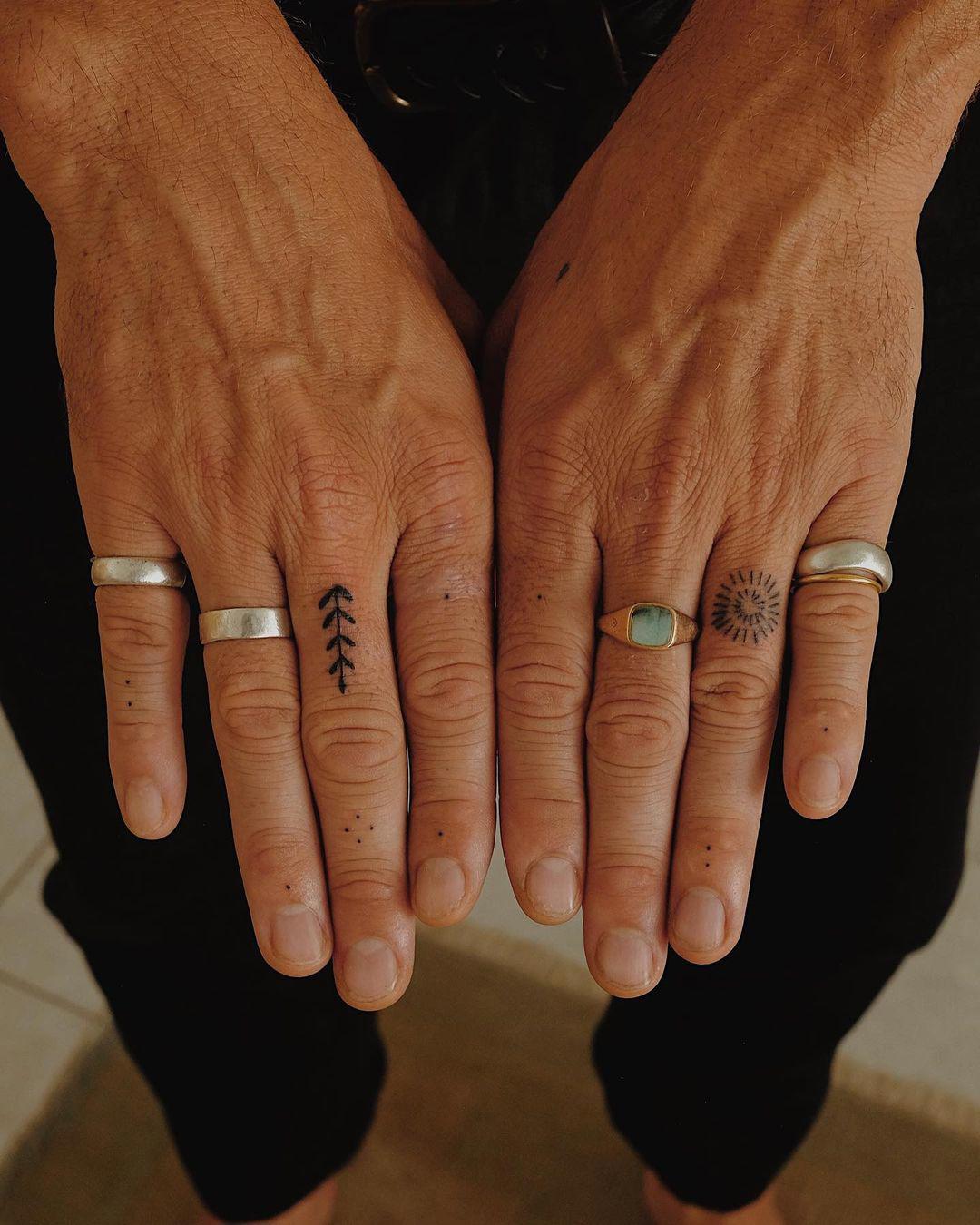 Tatuajes de puntos en los dedos.