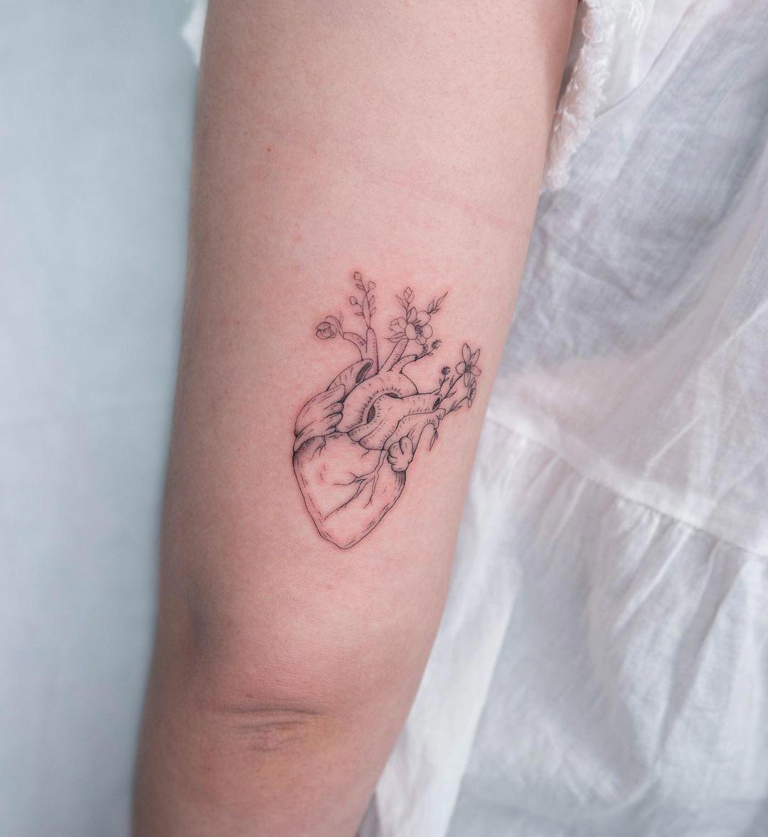 Tatuaje de flores y corazón anatómico